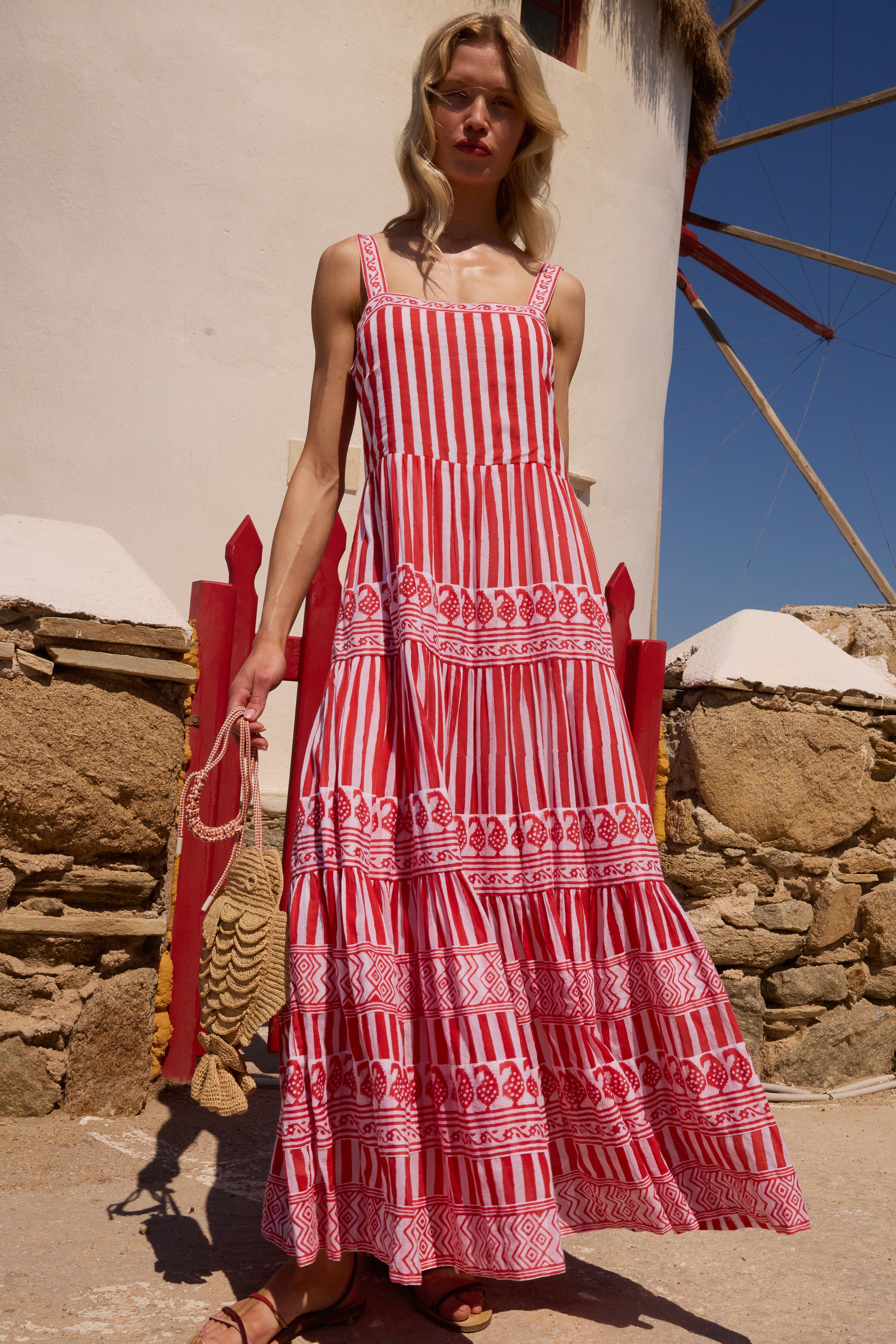 Red and white striped maxi dress with decorative geometric patterns and tiered ruffles