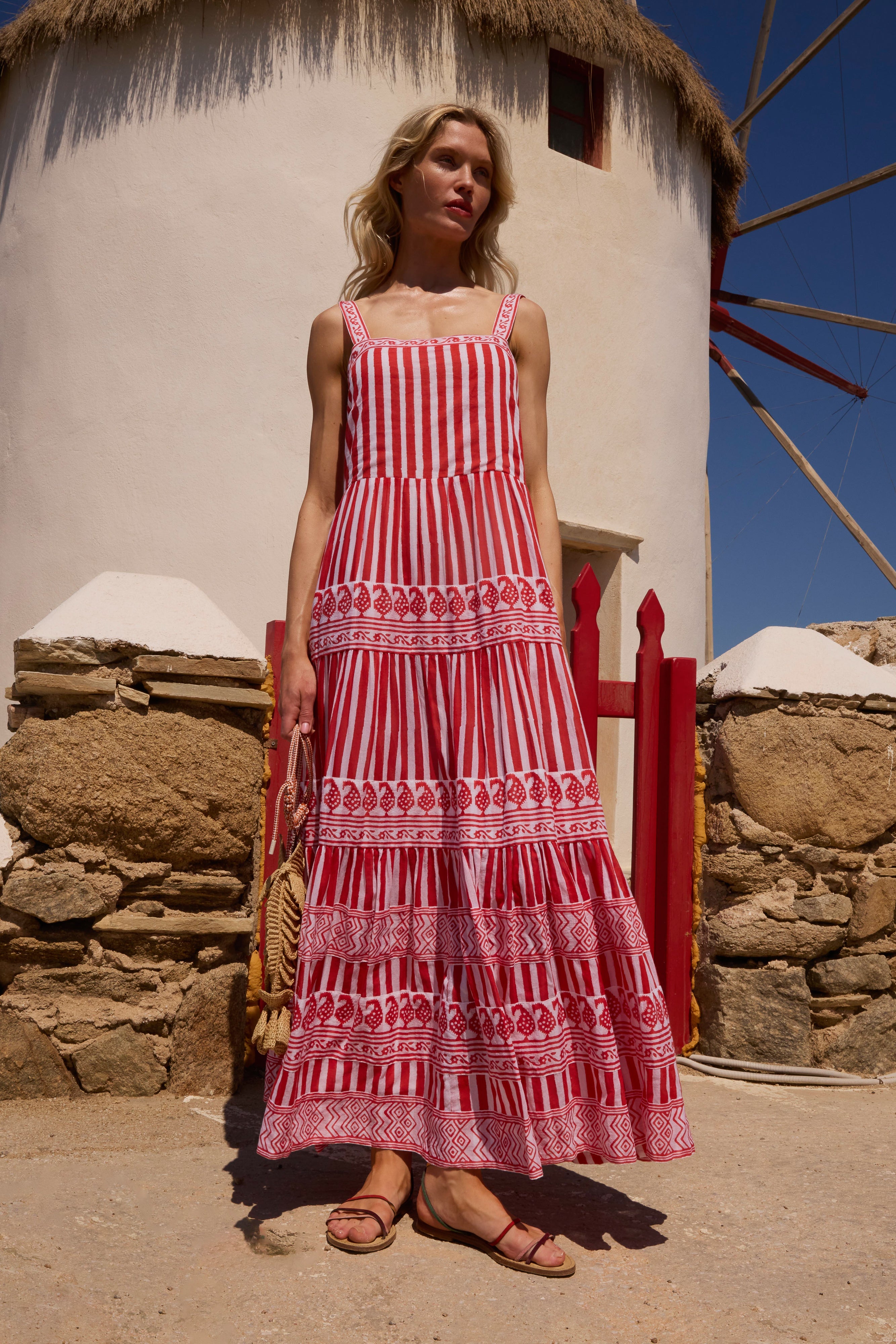 Woman wearing red and white striped maxi dress with decorative pattern bands