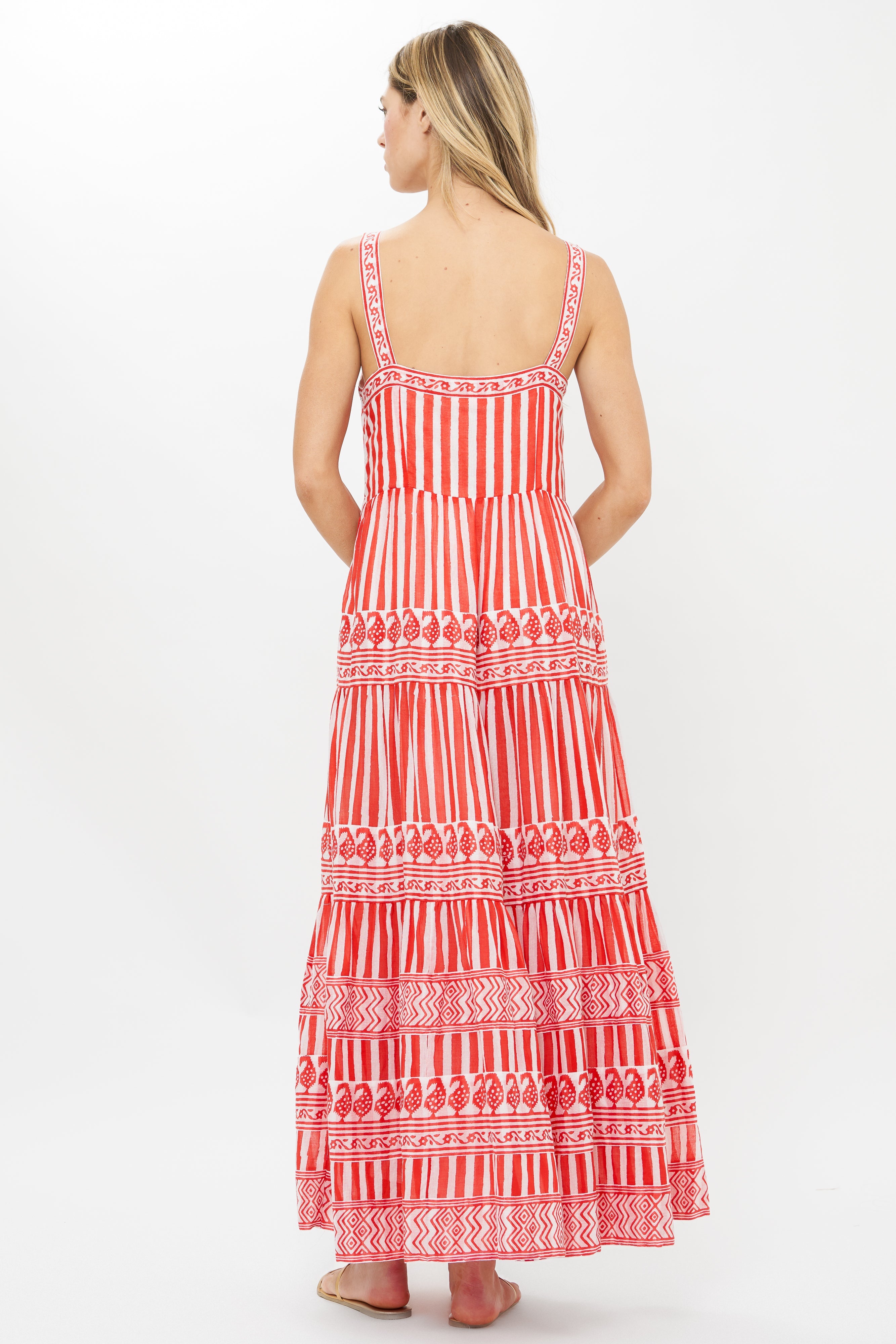 Back view of woman wearing red and white striped maxi dress with geometric patterns