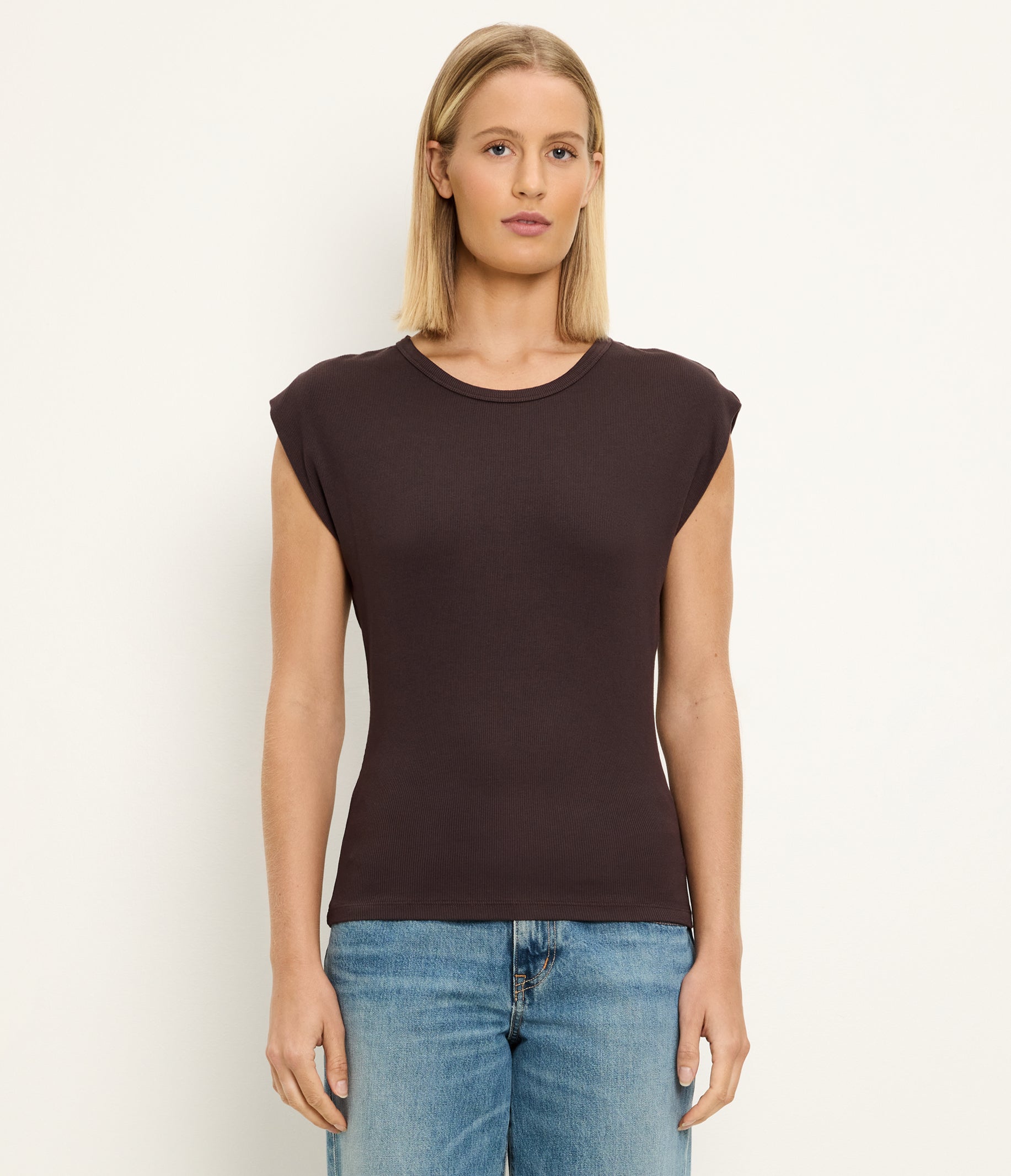 Woman wearing Michael Stars Joni crew neck sleeveless top in molasses brown with jeans