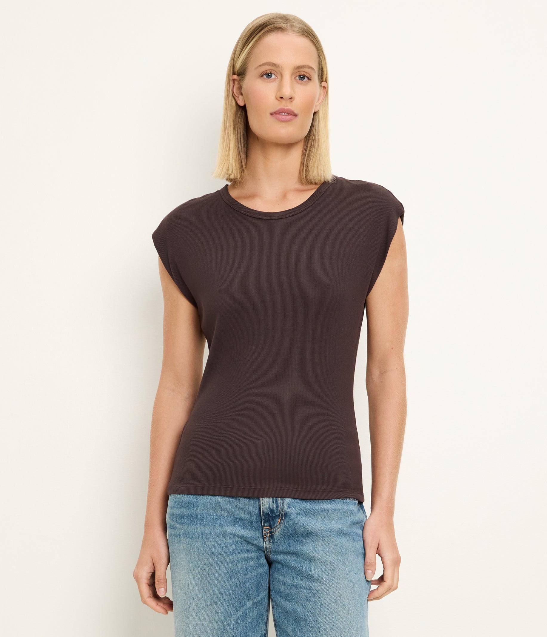 Woman wearing Michael Stars Joni crew neck sleeveless top in molasses brown with jeans