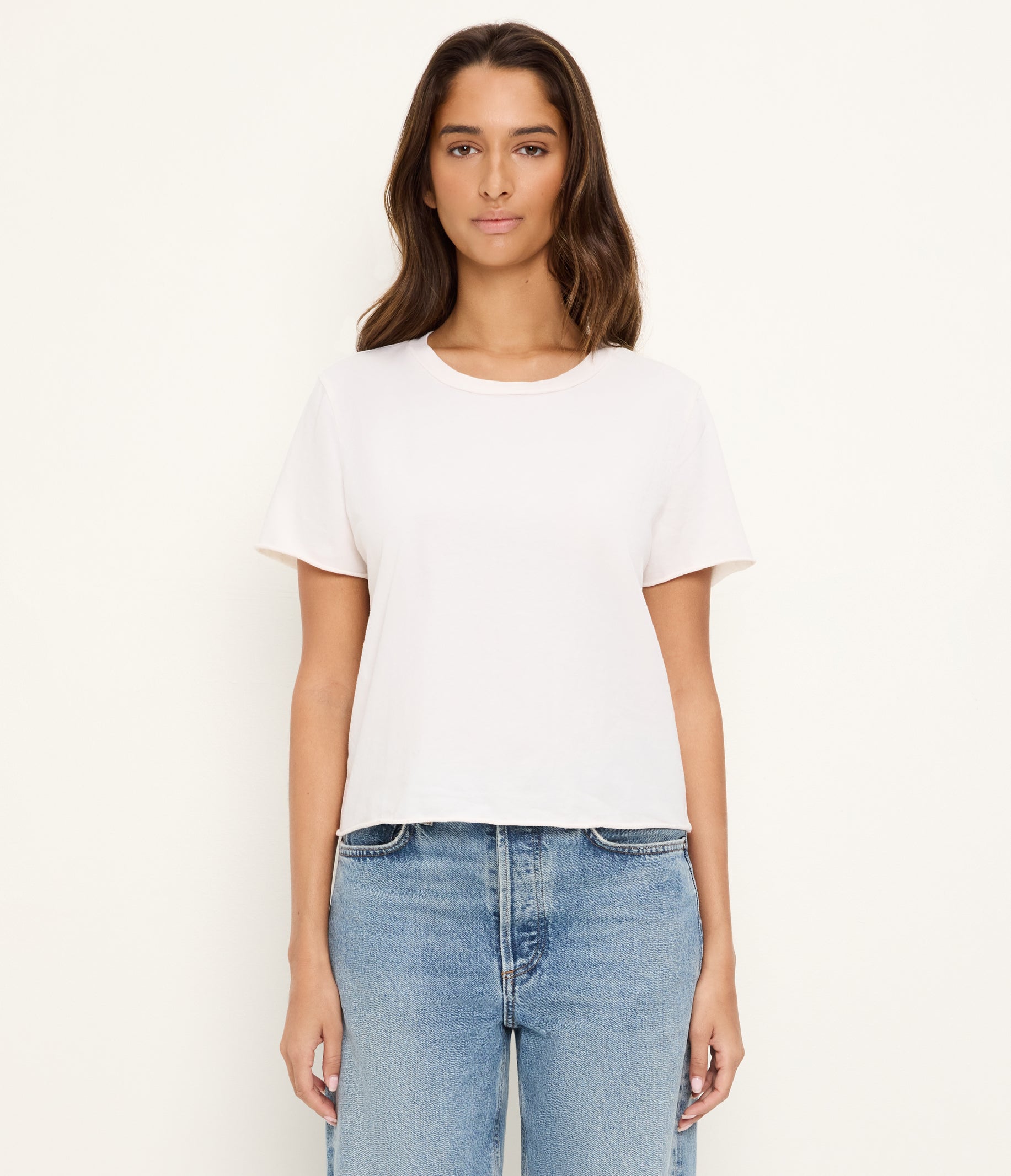 Woman wearing white Michael Stars Jackie rolled hem crop tee with blue jeans