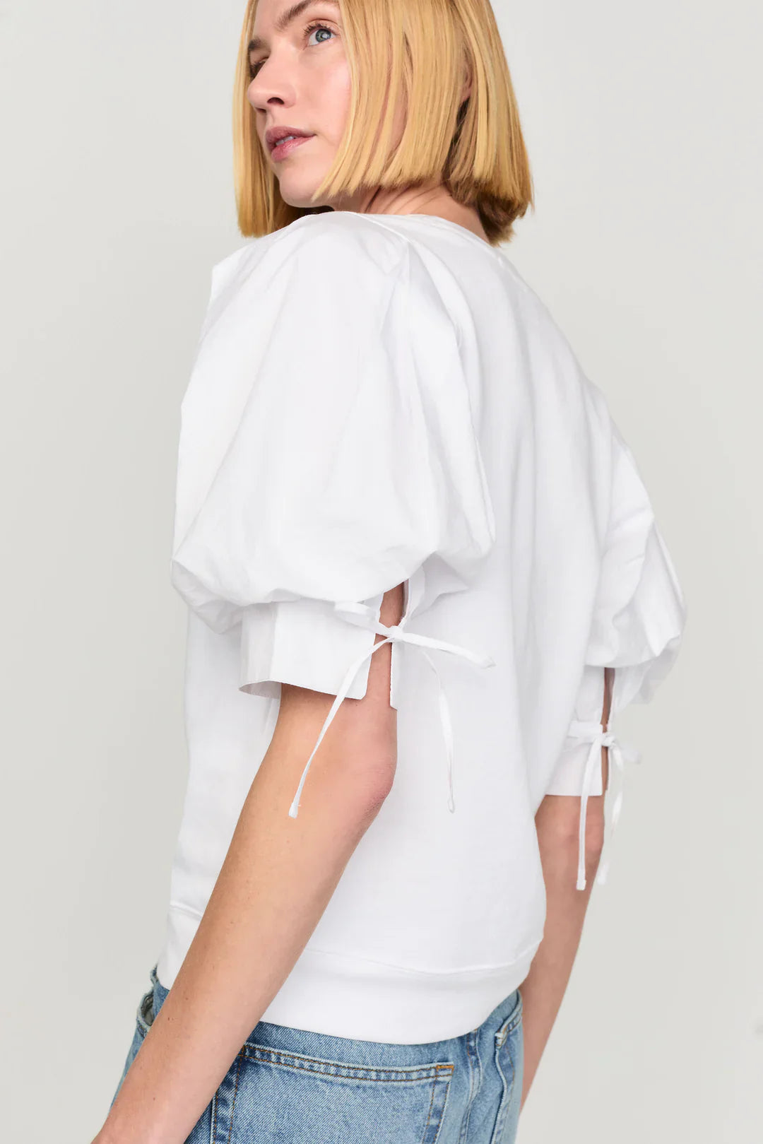 Marie Oliver Viva Popover in white with puffed sleeves and tie details on model