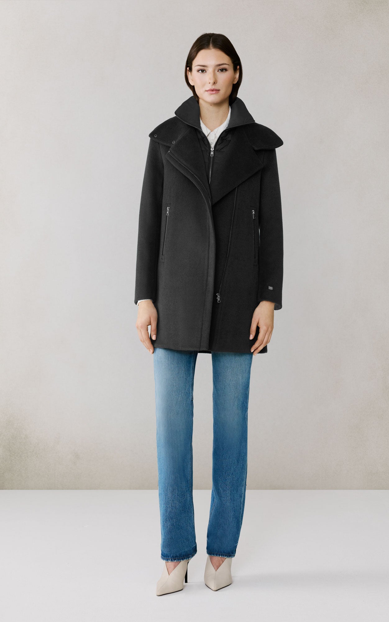 Woman wearing black Soia & Kyo Abbi wool coat with blue jeans and beige heels