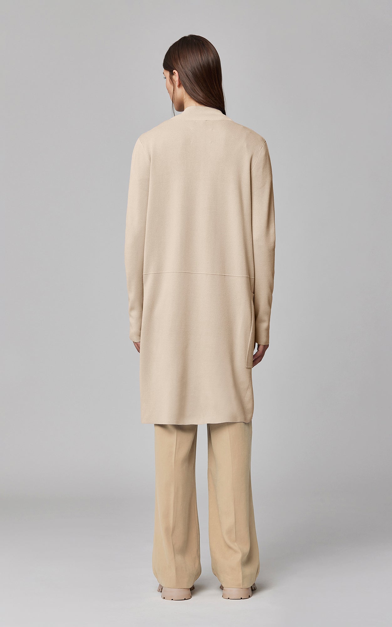 Woman wearing Soia & Kyo Benela cardigan in almond mist color, shown from back