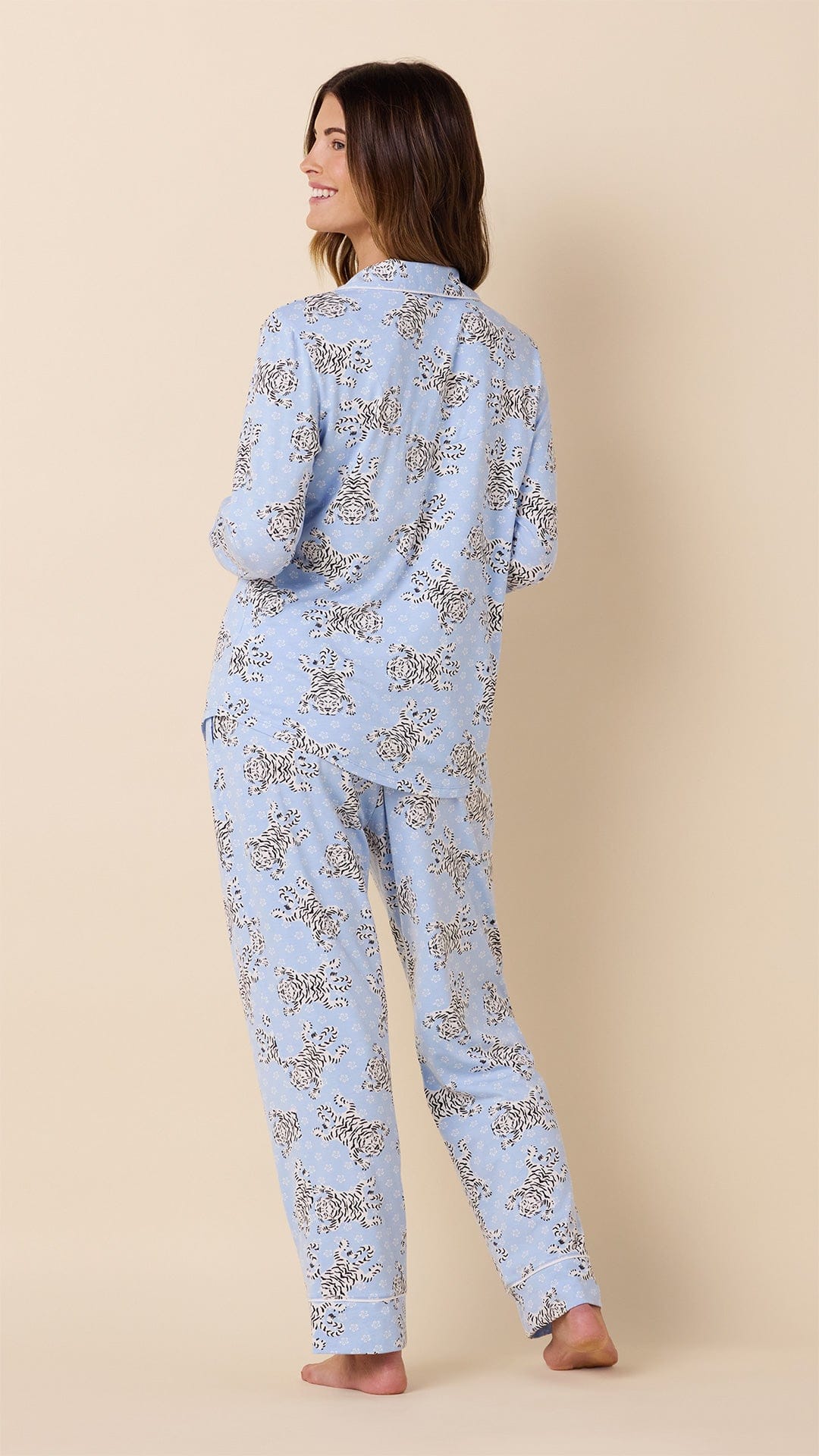 Woman wearing light blue long-sleeve pajama set with Bengal tiger print pattern