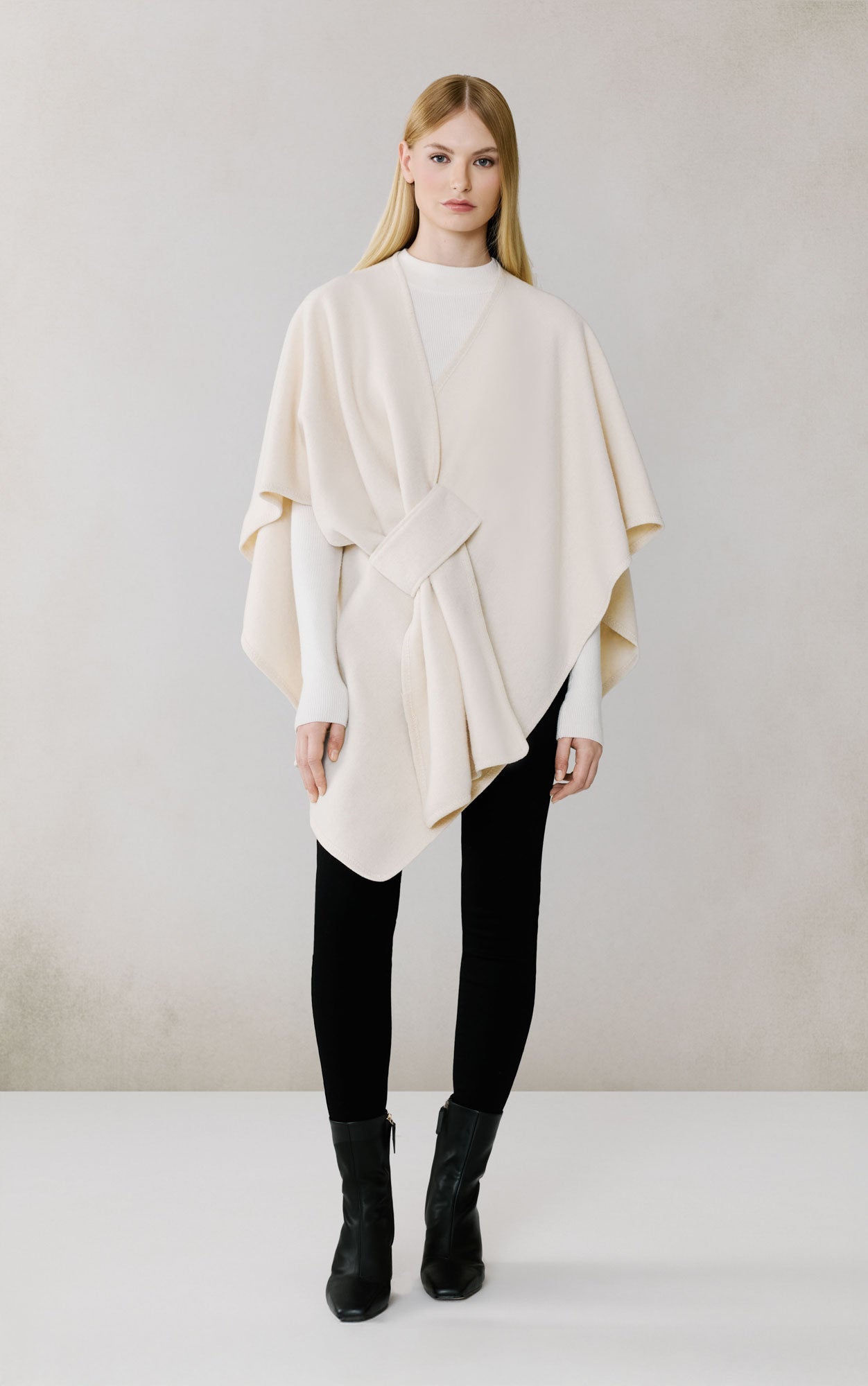Woman wearing cream colored Soia & Kyo Claudelle scarf with black pants and boots
