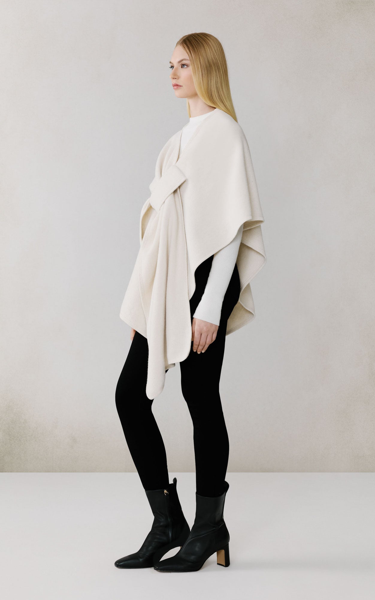 Woman wearing cream colored Soia & Kyo Claudelle scarf with black pants and boots