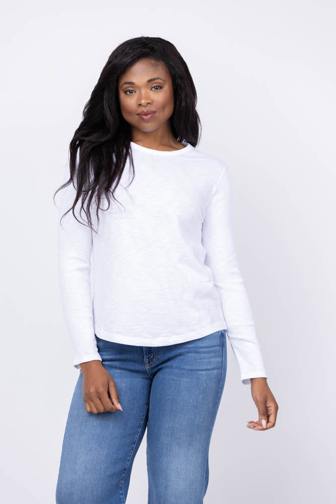 Woman wearing white long sleeve ribbed tee shirt with blue jeans on white background
