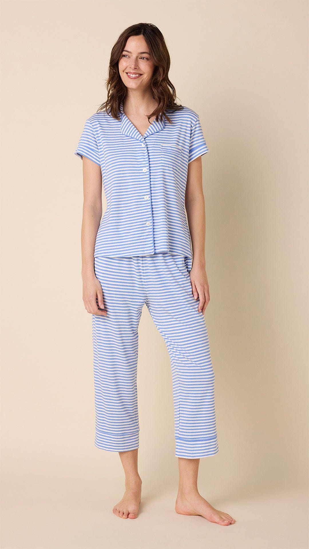 Woman wearing blue and white striped Pima knit capri pajama set with button-front top