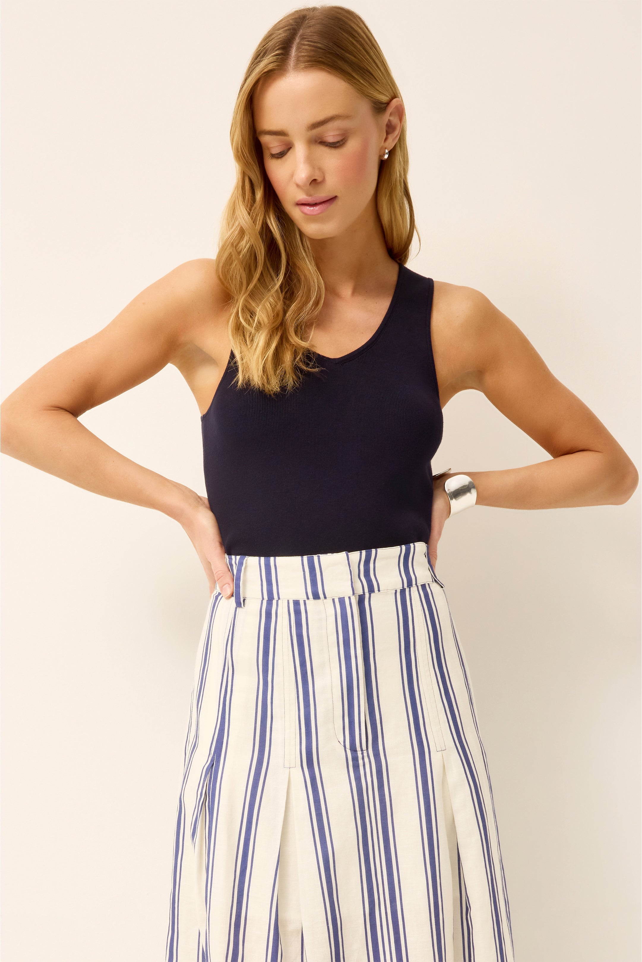 Woman wearing navy ribbed tank top with blue and white striped wide-leg pants