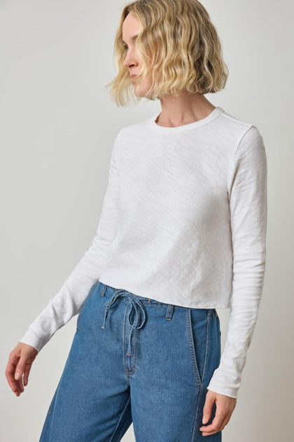 Woman wearing white long sleeve vintage slub top with blue drawstring pants