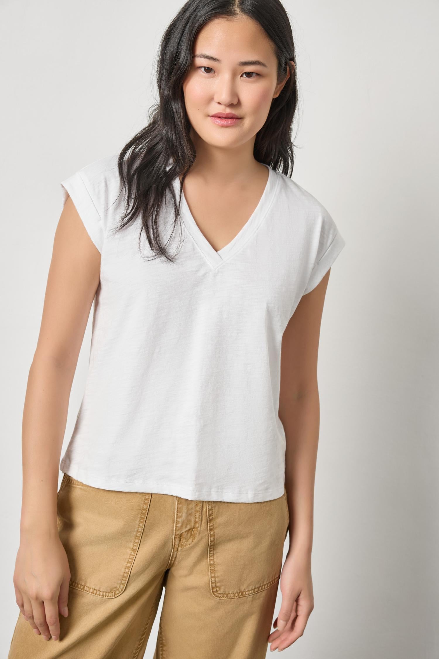Woman wearing white Lilla P cuff sleeve boxy top with v-neck and tan pants