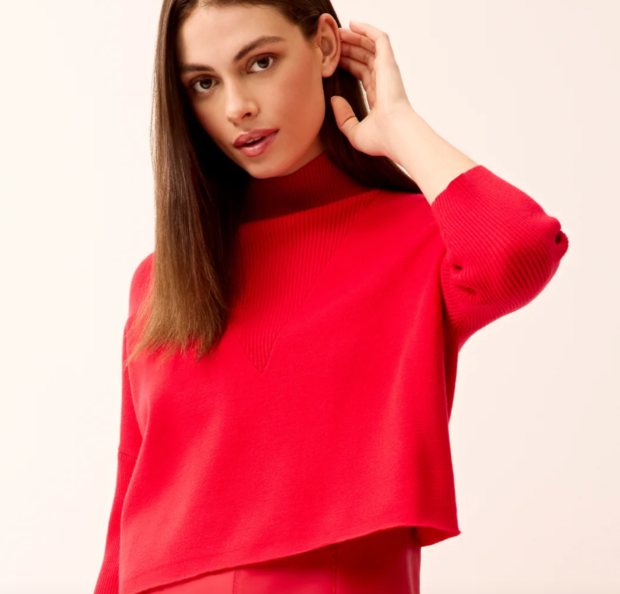 Woman wearing bright red Marie Oliver Claudie Popover sweater with mock neck