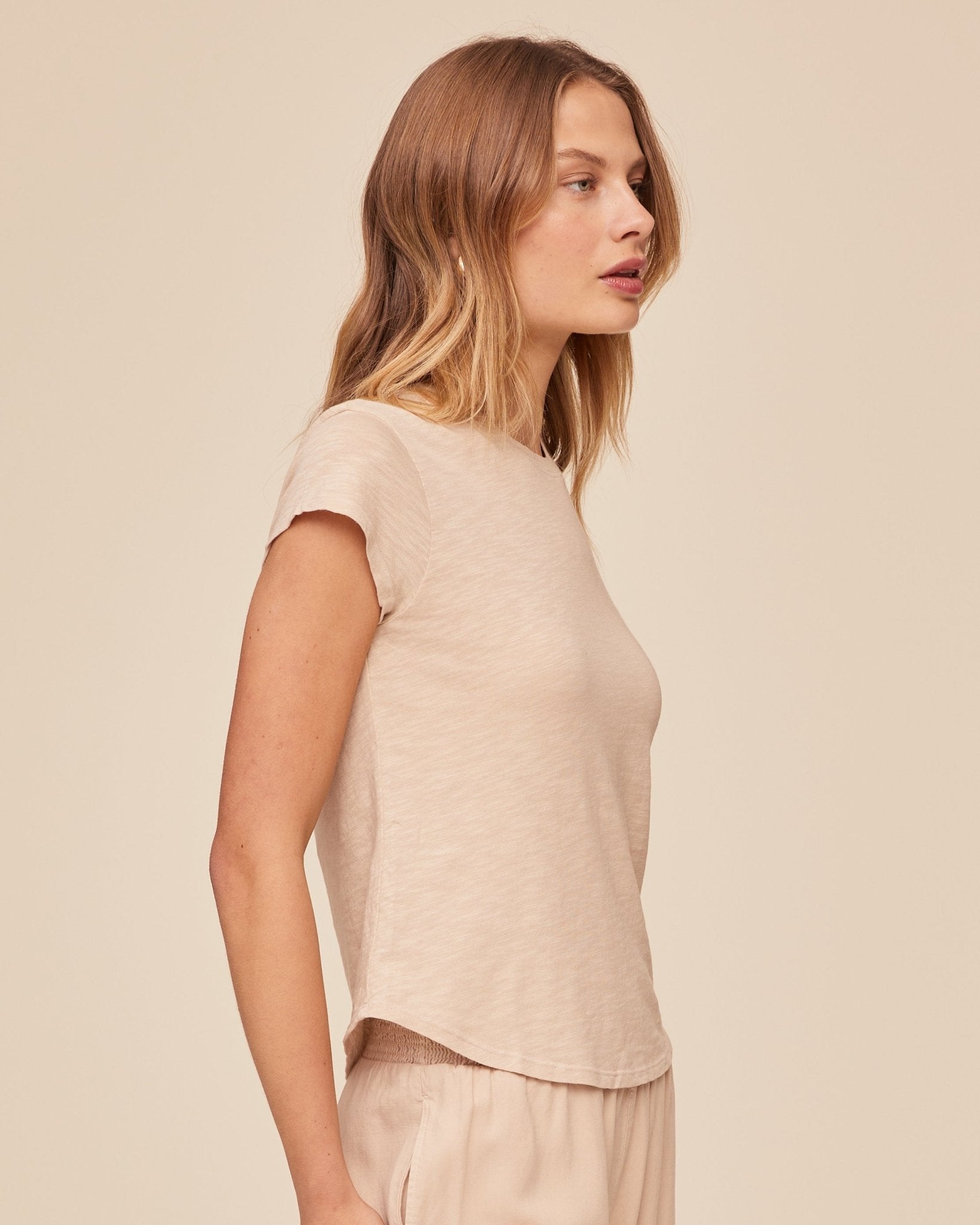 Woman wearing beige linen short-sleeve crew neck tee with relaxed fit