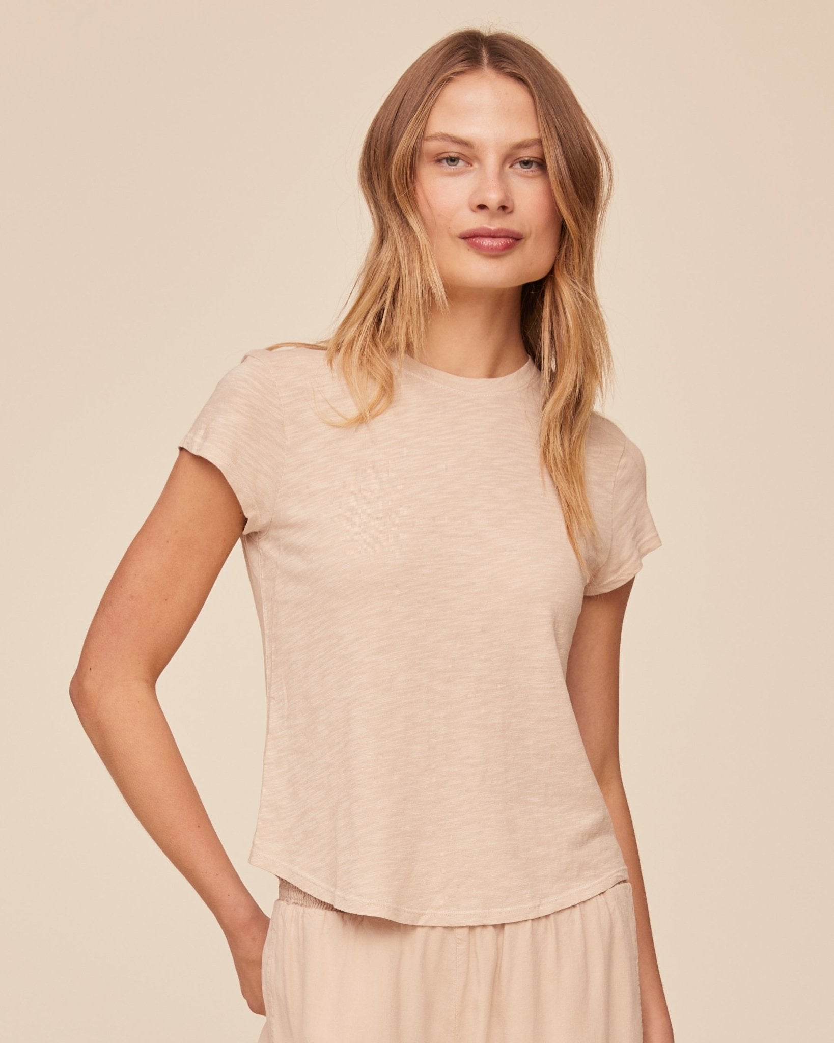 Woman wearing beige linen sand colored short sleeve crew neck t-shirt