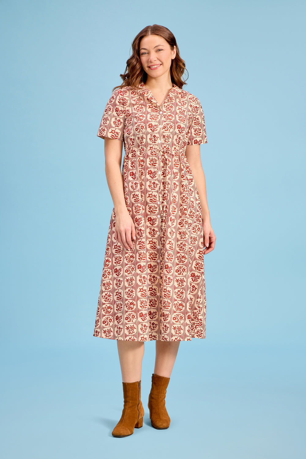 Woman wearing Livro Sutton Dress in brick bloom floral print with tan ankle boots