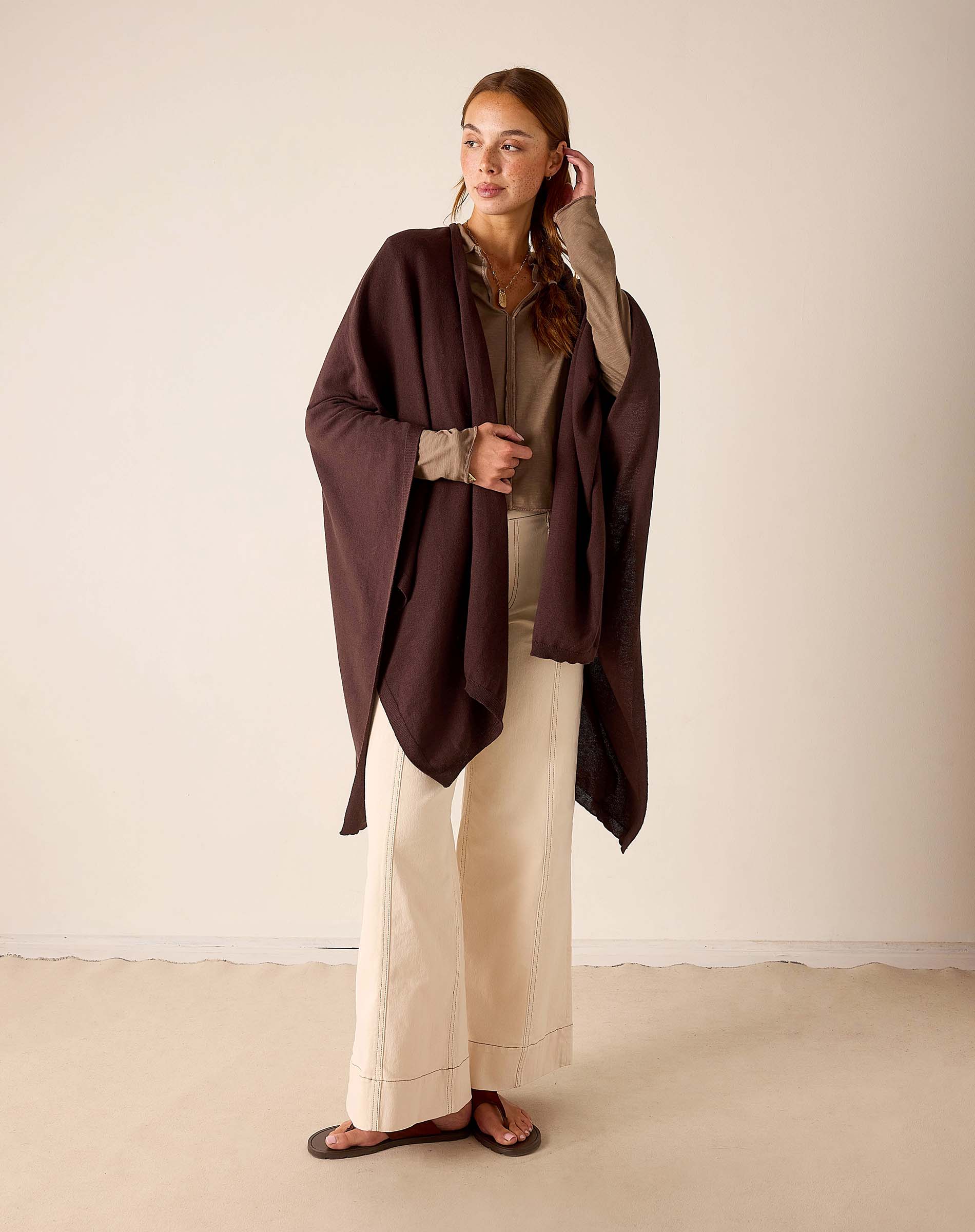 Model wearing Mer-Sea Charleston Wrap in chocolate brown over cream wide-leg trousers