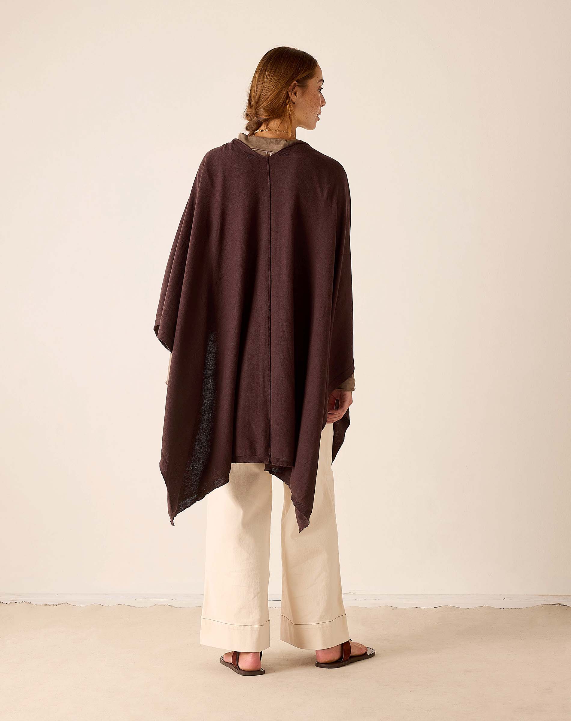 Model wearing Mer-Sea Charleston Wrap in chocolate brown over cream wide-leg trousers, back view