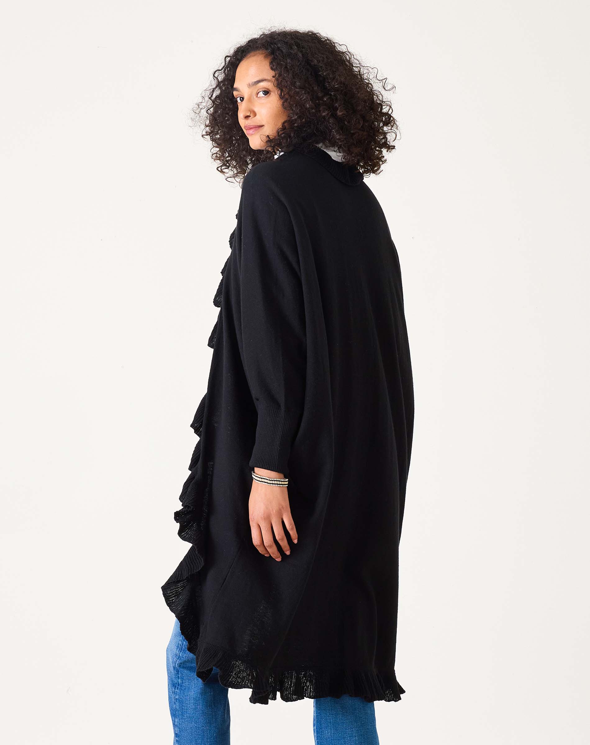 Woman wearing black long ruffle-trim open-front knit kimono cardigan from behind