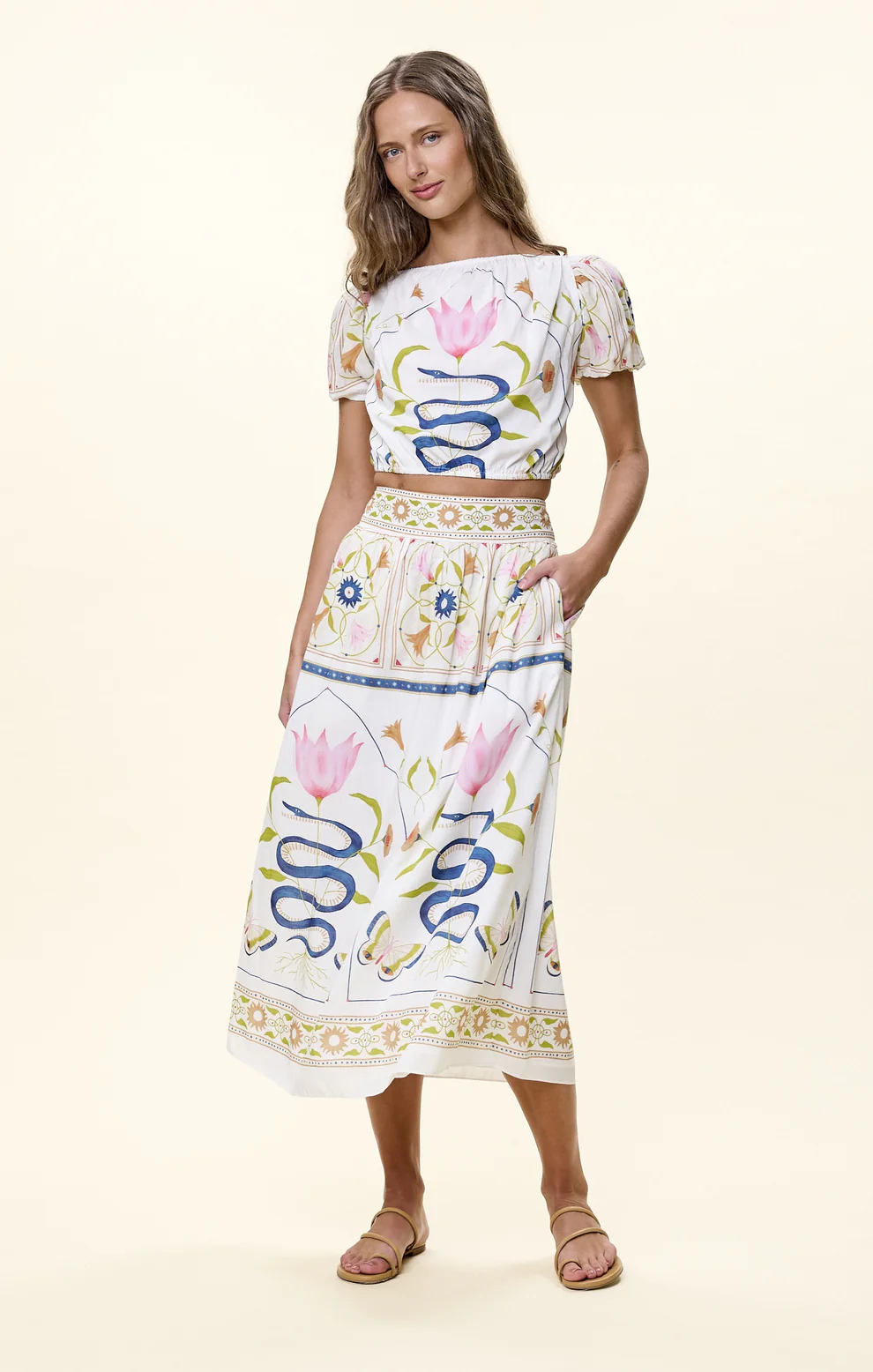 Woman wearing white maxi skirt with blue snake and pink floral print pattern