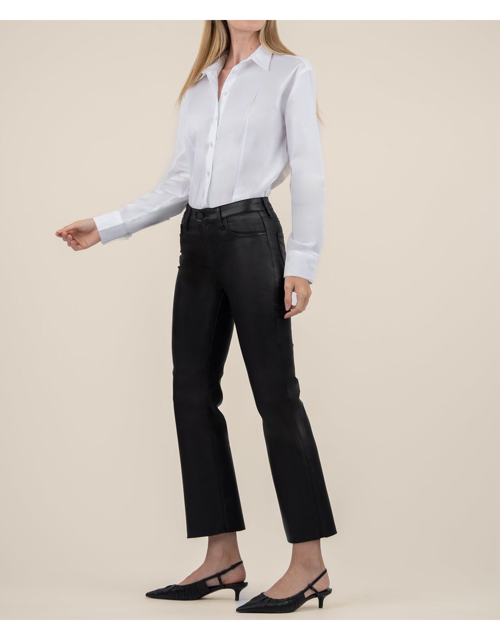 Woman wearing white button-up shirt with black coated flare jeans and black heels