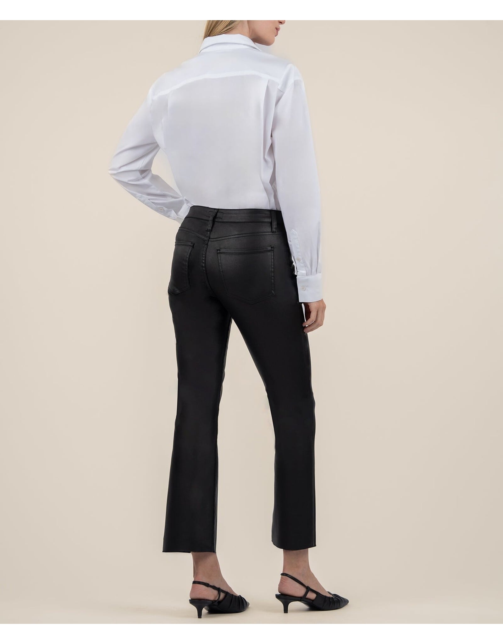 Woman wearing black coated flare jeans with white button-down shirt, back view