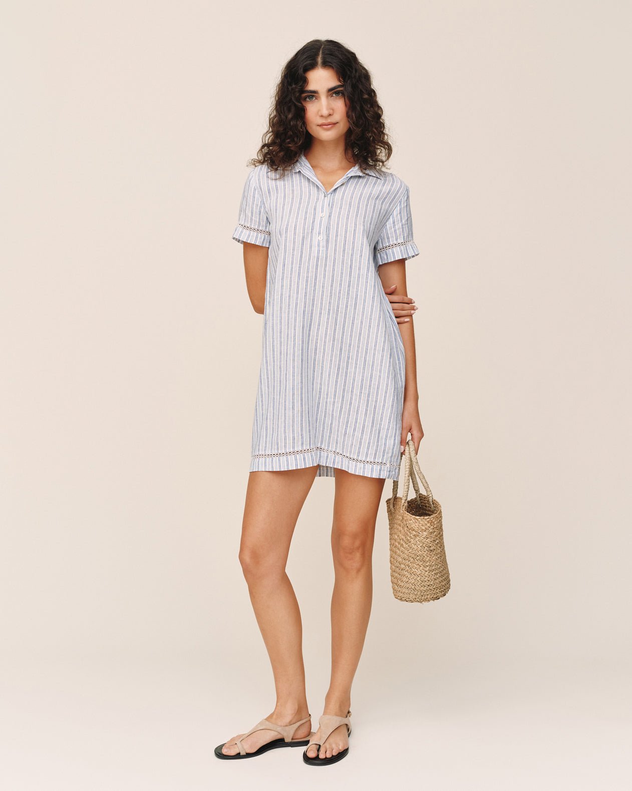 Woman wearing Bella Dahl short sleeve striped shirt dress with woven bag and sandals
