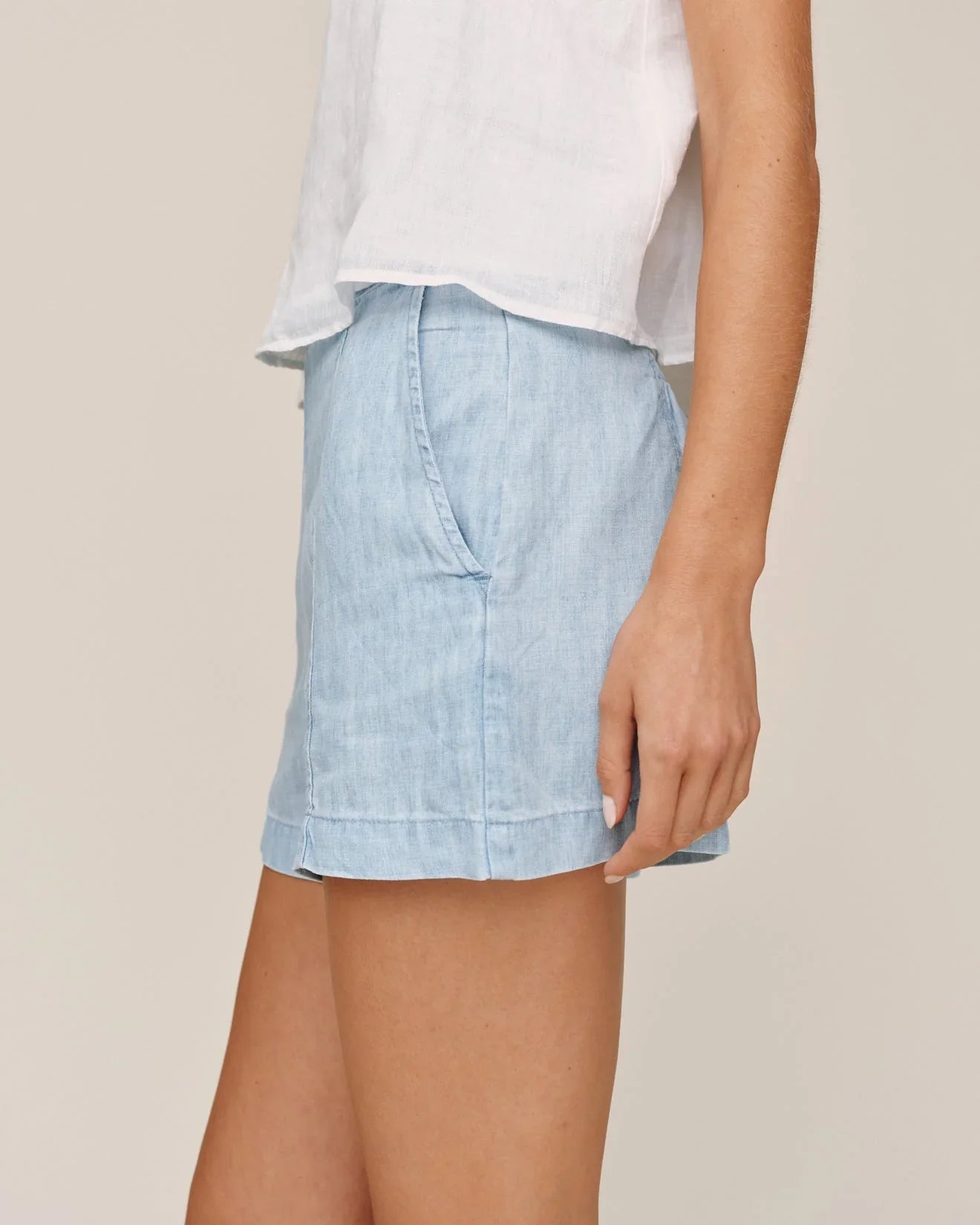 Light blue denim shorts with smocked back seam and cuffed hem styled with white top
